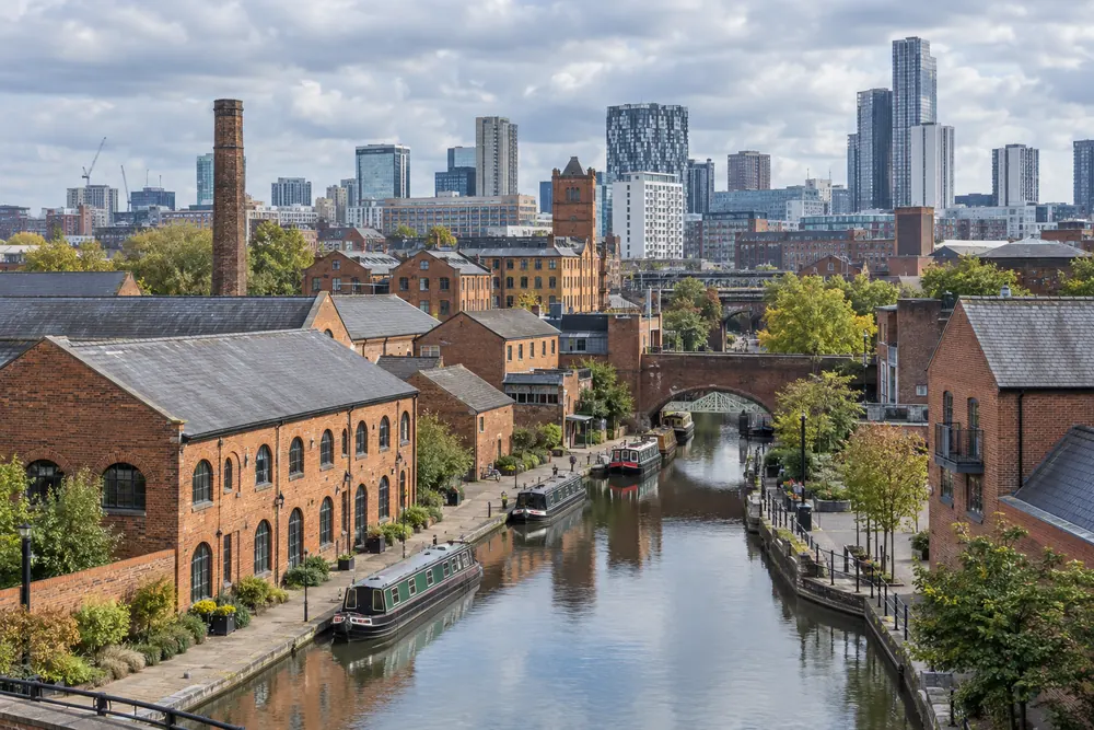 Birmingham canal lined by red brick buildings and a modern skyline